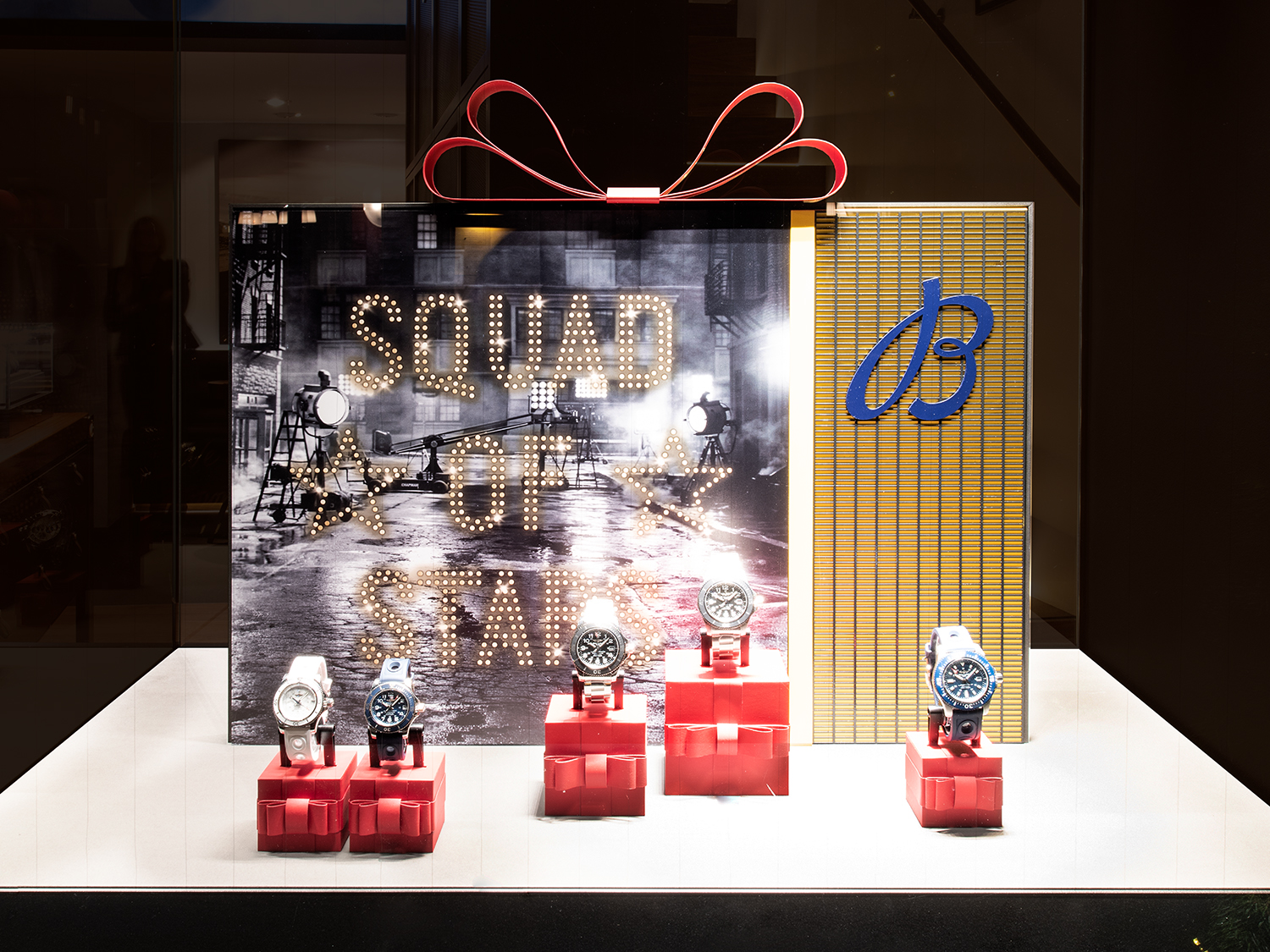 Breitling-Schaufenster mit "Squad of Stars"-Thema und luxuriösen Uhren auf roten Geschenkschachteln, entworfen von MORE PIOUS STUDIOS. Integriertes window system.