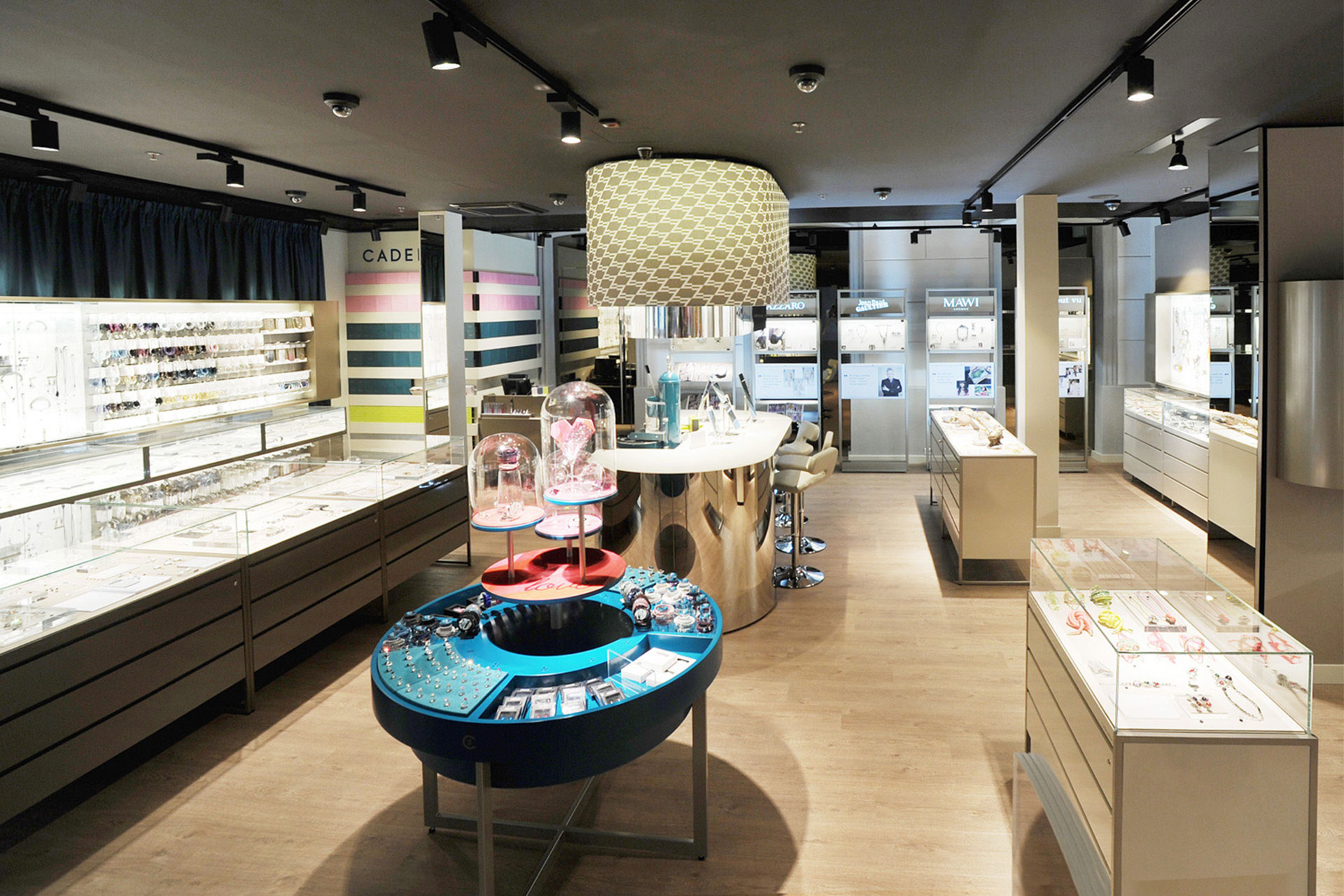 Innenansicht des Cadenzza Stores mit farbenfroher Schmuckpräsentation und eleganten Display-Vitrinen, gestaltet von MORE PIOUS STUDIOS.