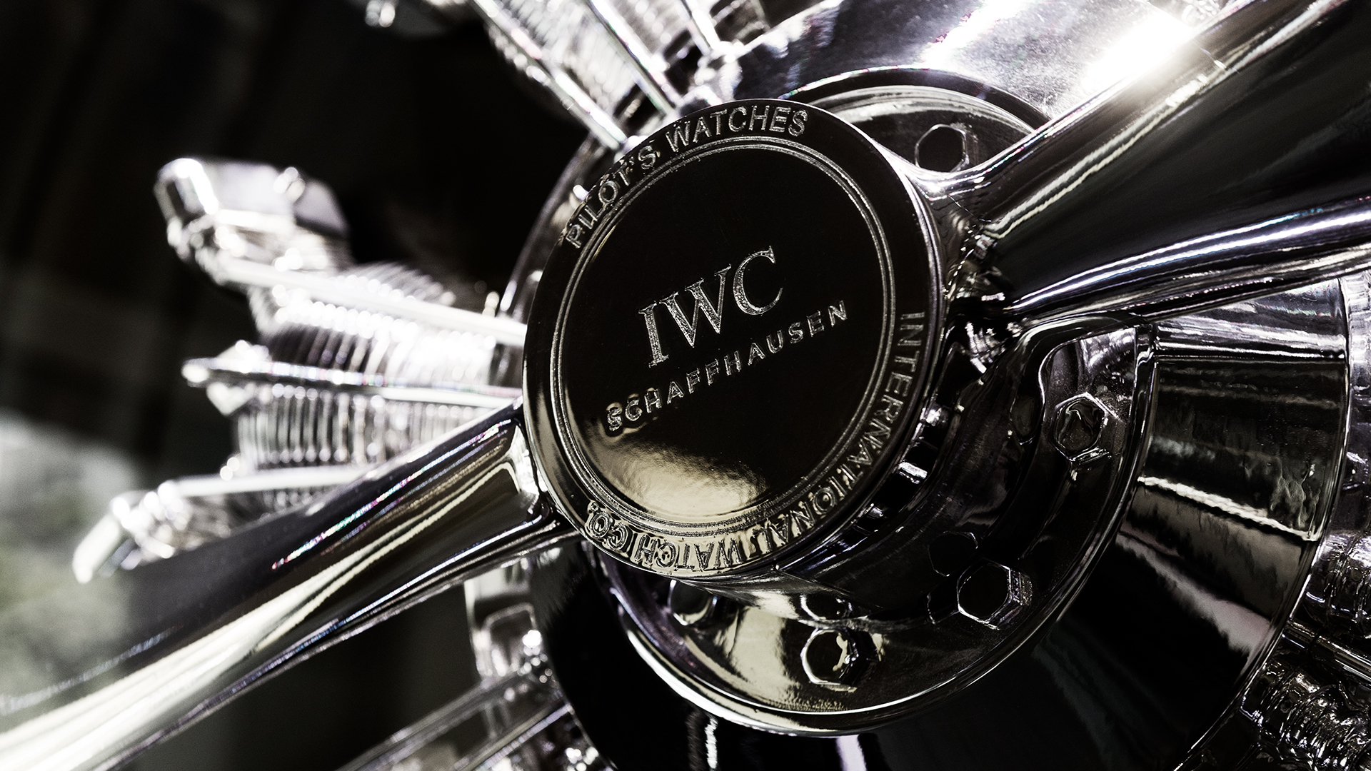 Nahaufnahme des IWC Schaffhausen-Logos auf einer verchromten Flugzeugmotorinstallation im Rahmen der IWC Pilot-Kampagne.