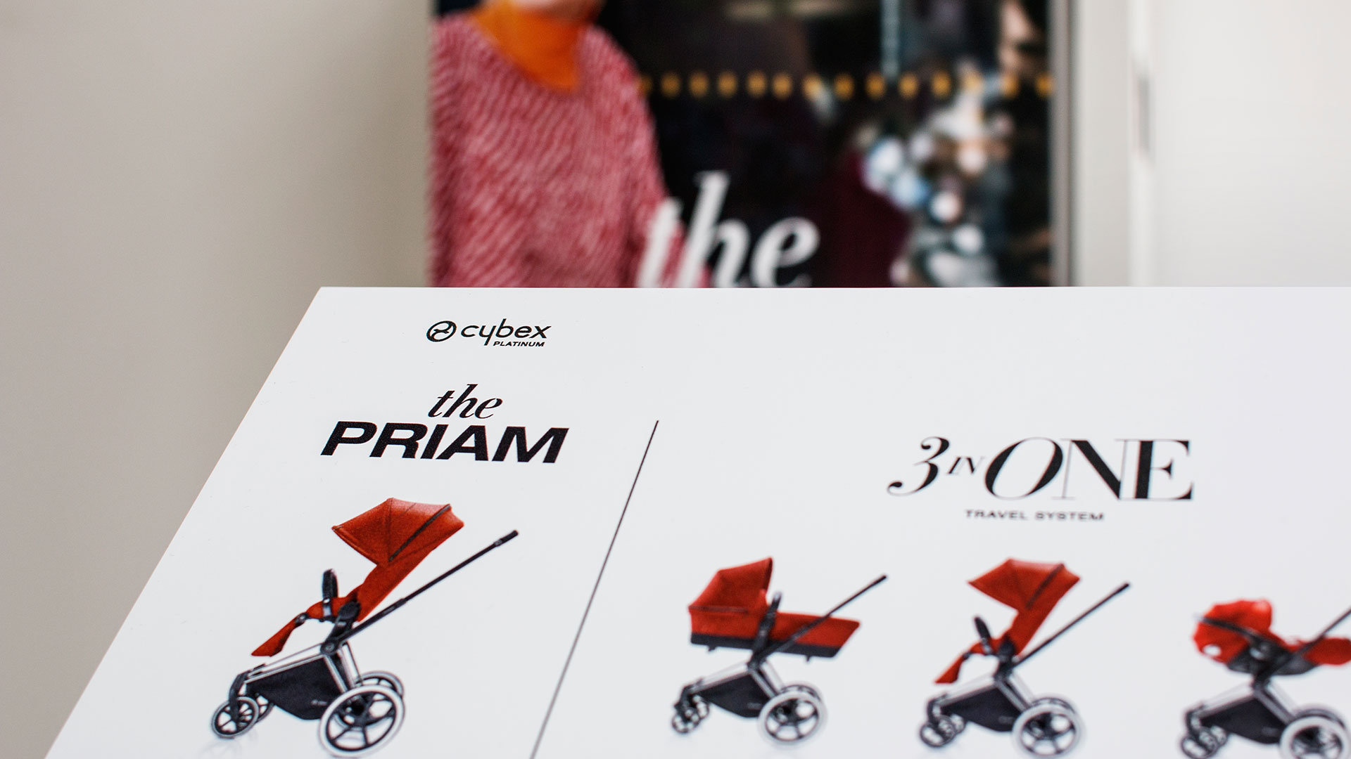 Cybex Priam 3-in-1 Kinderwagen-System auf einem Werbedisplay, konzipiert von MORE PIOUS STUDIOS für effektive Visual Communication.