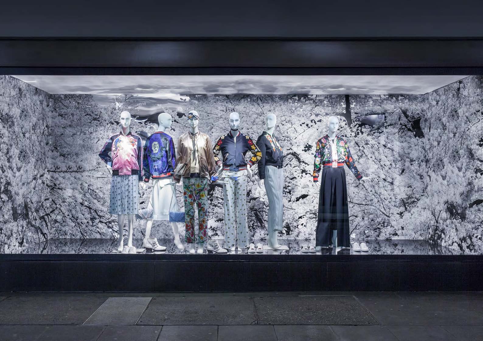 Schaufenster mit Mannequins in farbenfroher Mode vor einer romantischen Kulisse aus Kirschblüten, gestaltet von MORE PIOUS STUDIOS.