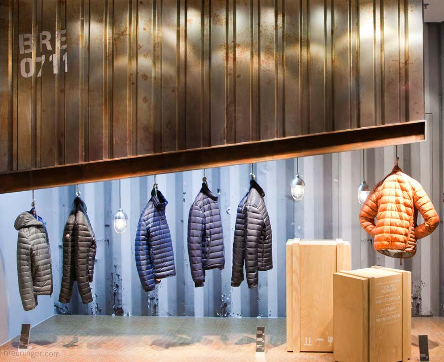 Industrial-Style Schaufensterdesign mit Winterjacken und Holzelementen, gestaltet von MORE PIOUS STUDIOS