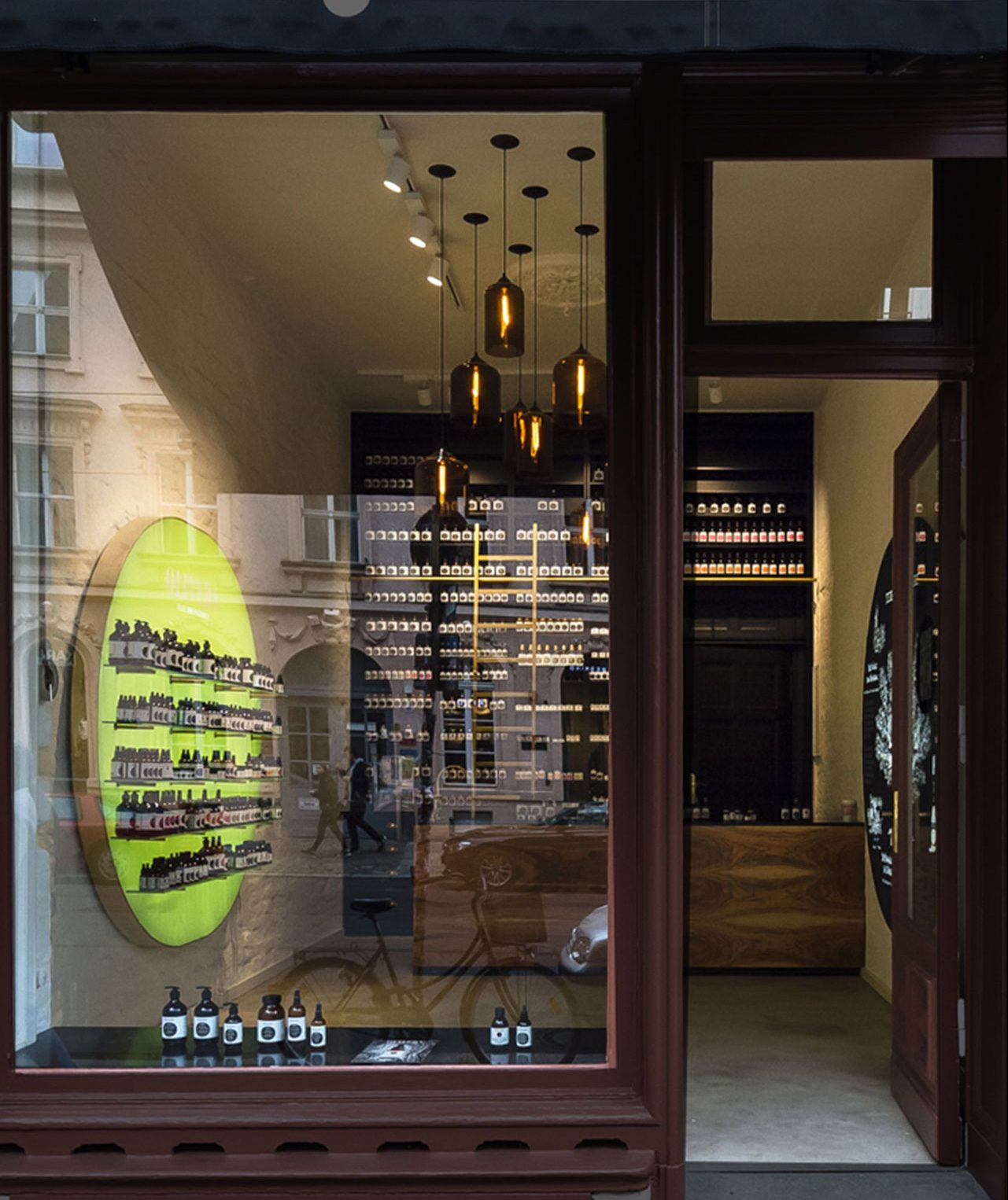 Außenansicht des Oliveda Flagship-Stores mit Blick ins Ladeninnere und hängenden Leuchten