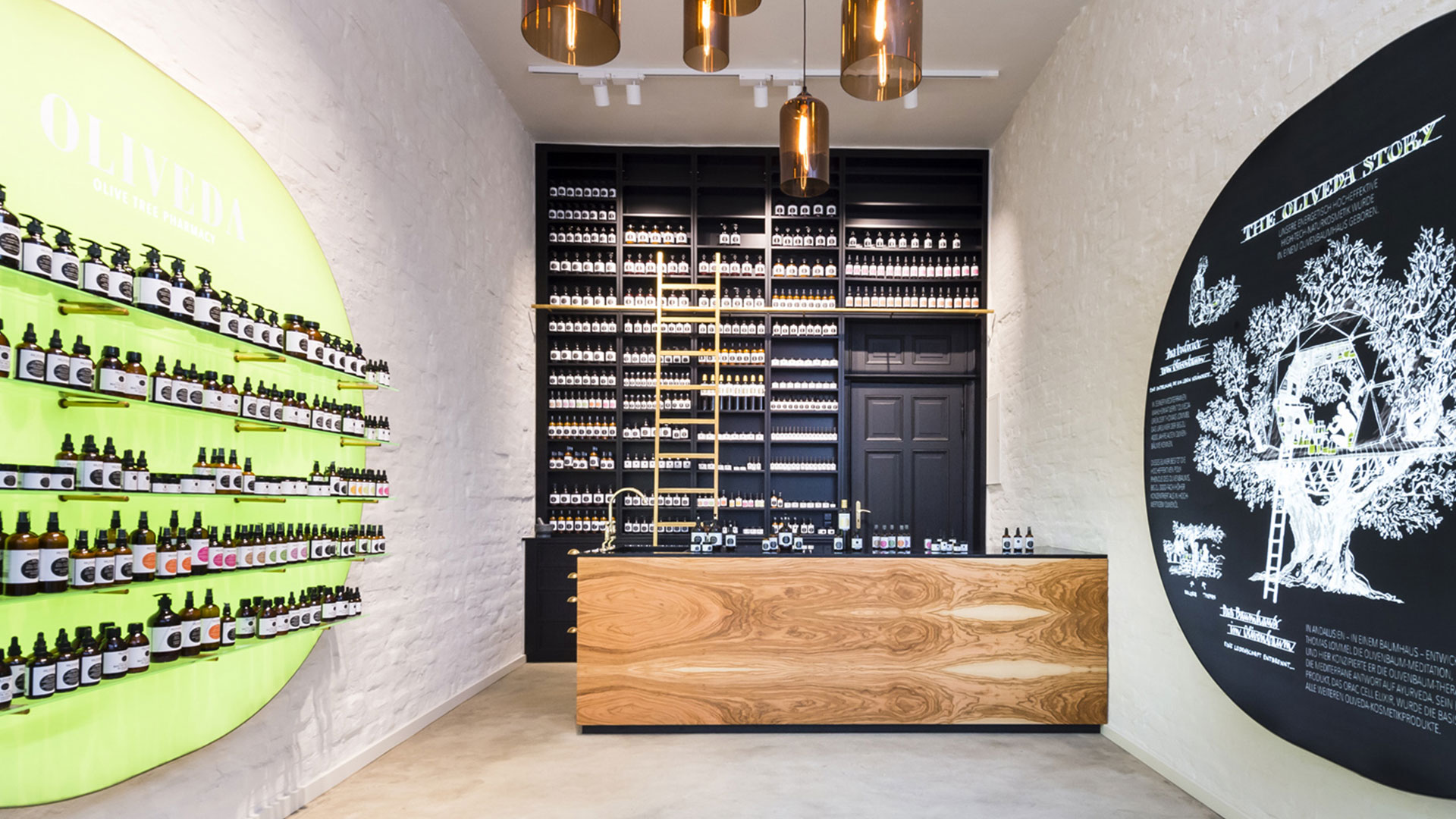 Oliveda Flagship-Store mit Holztheke, schwarzer Regalwand und großer Grafik
