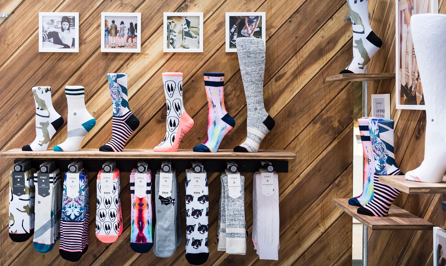 Detailansicht der Produktpräsentation am STANCE Messestand, mit farbenfrohen Socken und Holzverkleidung, gestaltet von MORE PIOUS STUDIOS.