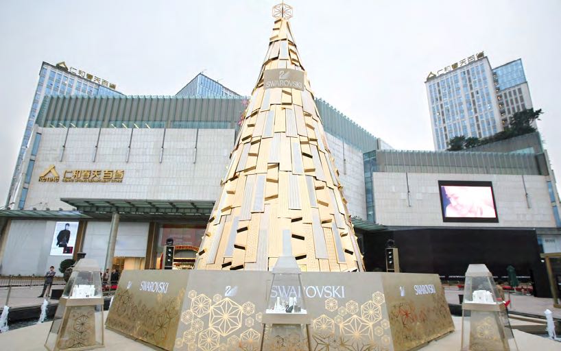 Swarovski Schaufenster mit goldenem Weihnachtsbaum und Schmuckpräsentation, gestaltet von MORE PIOUS STUDIOS