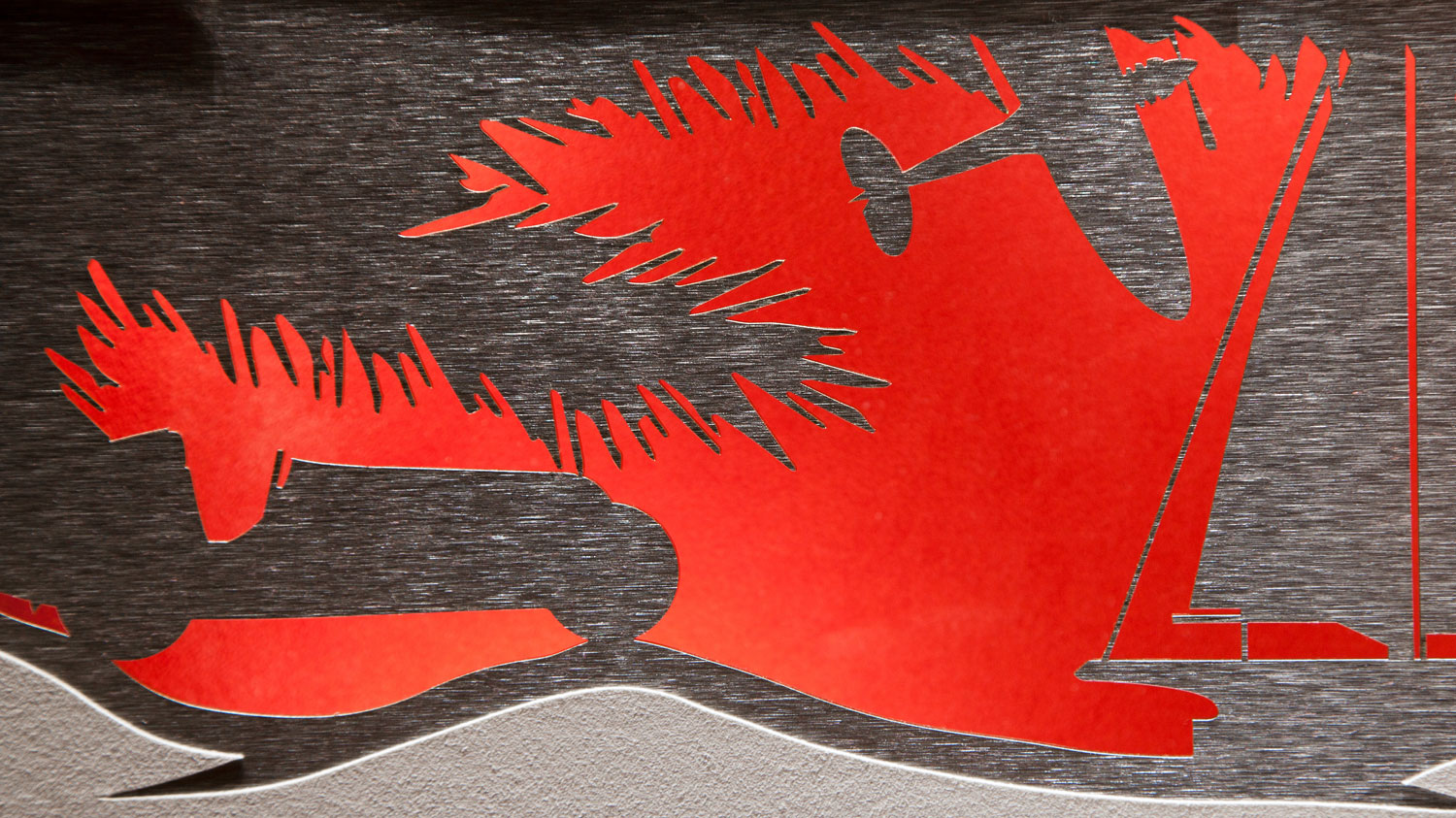 Nahaufnahme eines roten und silbernen Weihnachtsdesigns mit Scherenschnitt-Motiv, Teil der IWC-Kampagne von MORE PIOUS STUDIOS.