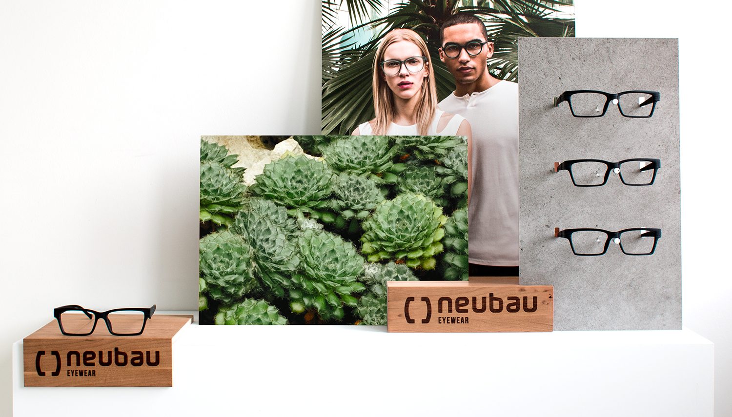 Präsentation von Neubau Eyewear Produkten mit natürlichen Elementen und Brillen auf Betonuntergrund, gestaltet von MORE PIOUS STUDIOS.