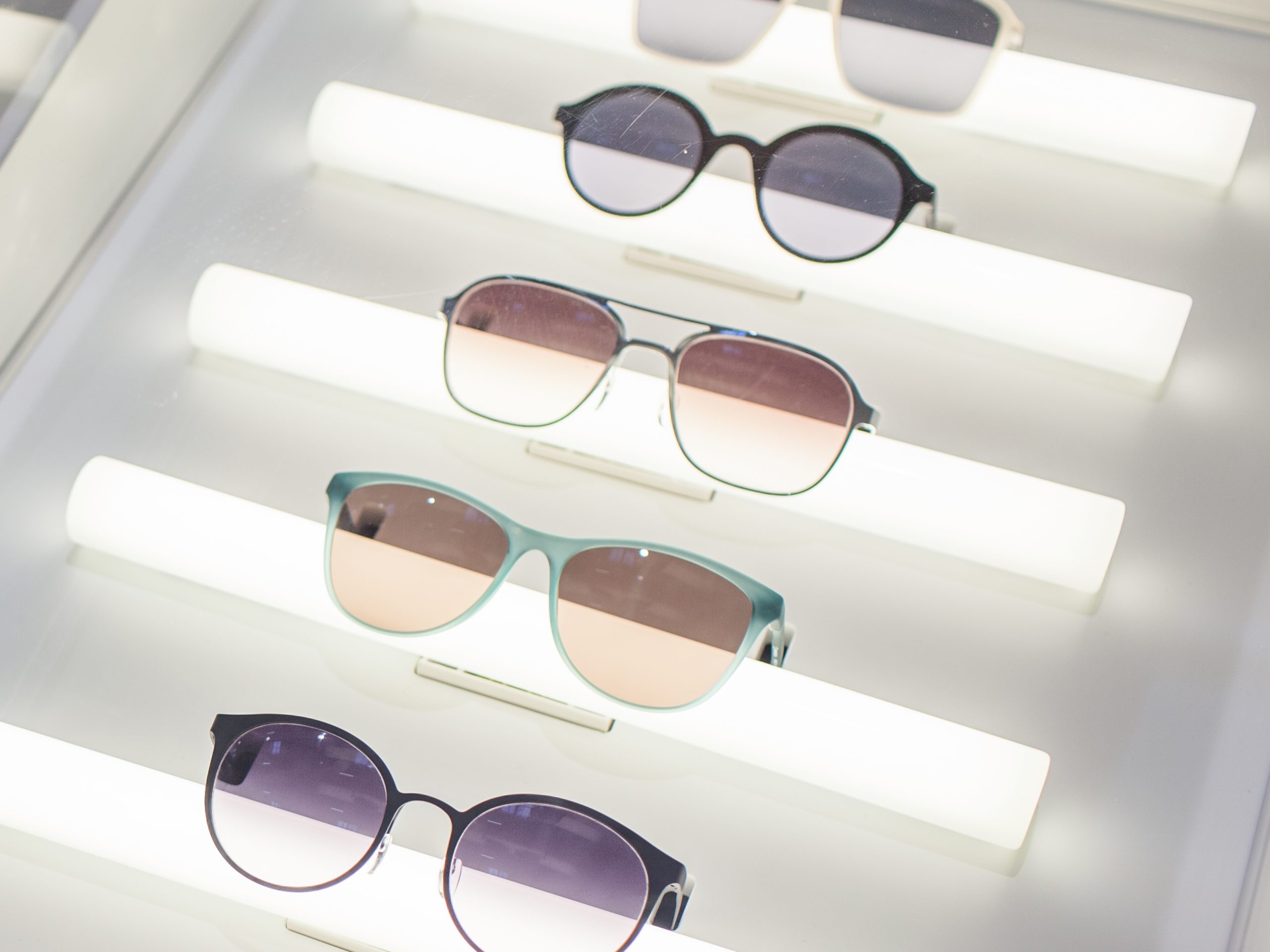 Detailaufnahme eines Displays mit Sonnenbrillen und beleuchteten Regalen, entwickelt von MORE PIOUS STUDIOS.