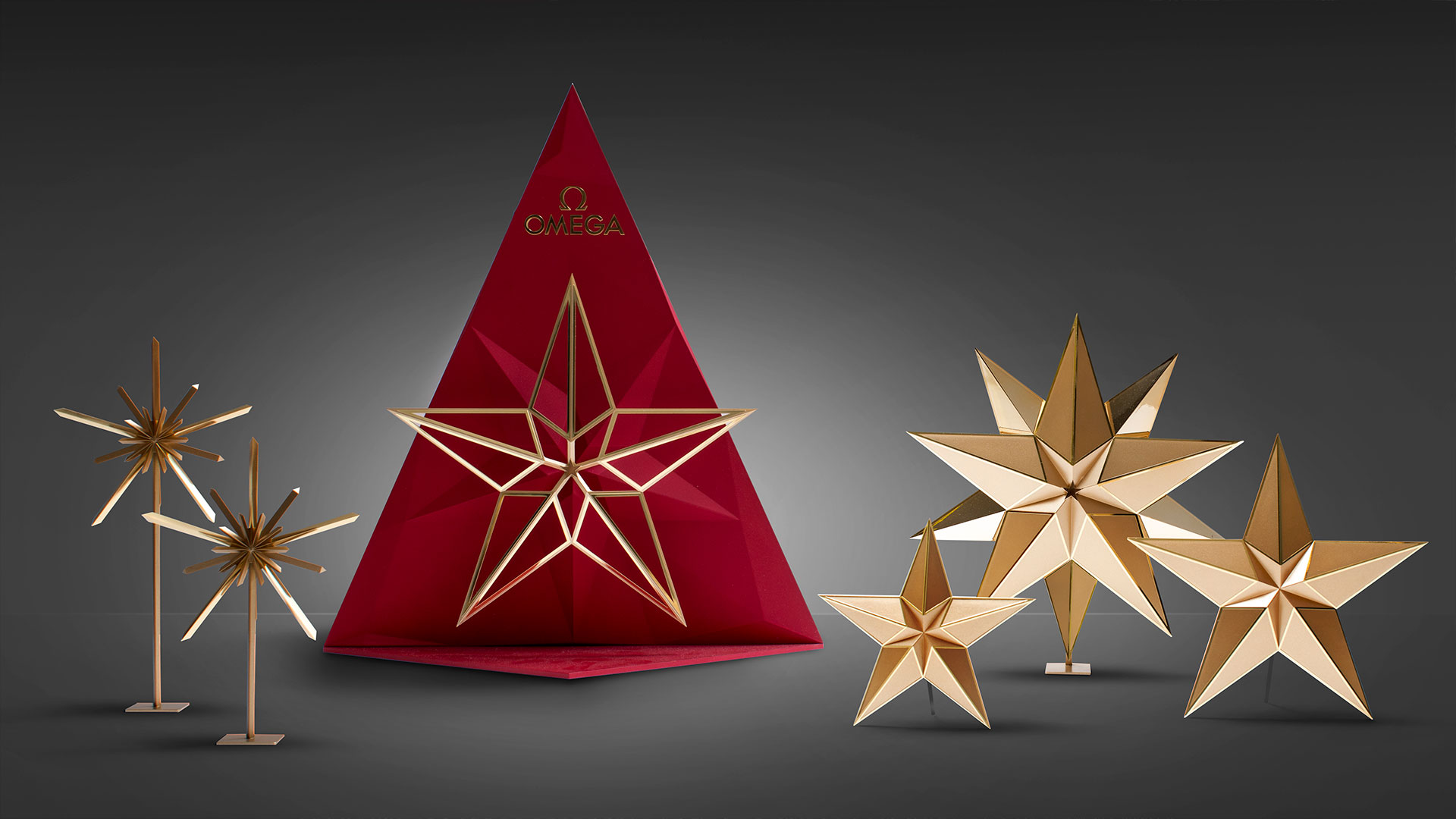 Omega-Dekoration mit roten und goldenen geometrischen Sternen, entworfen von MORE PIOUS STUDIOS für visuelle Kommunikation.