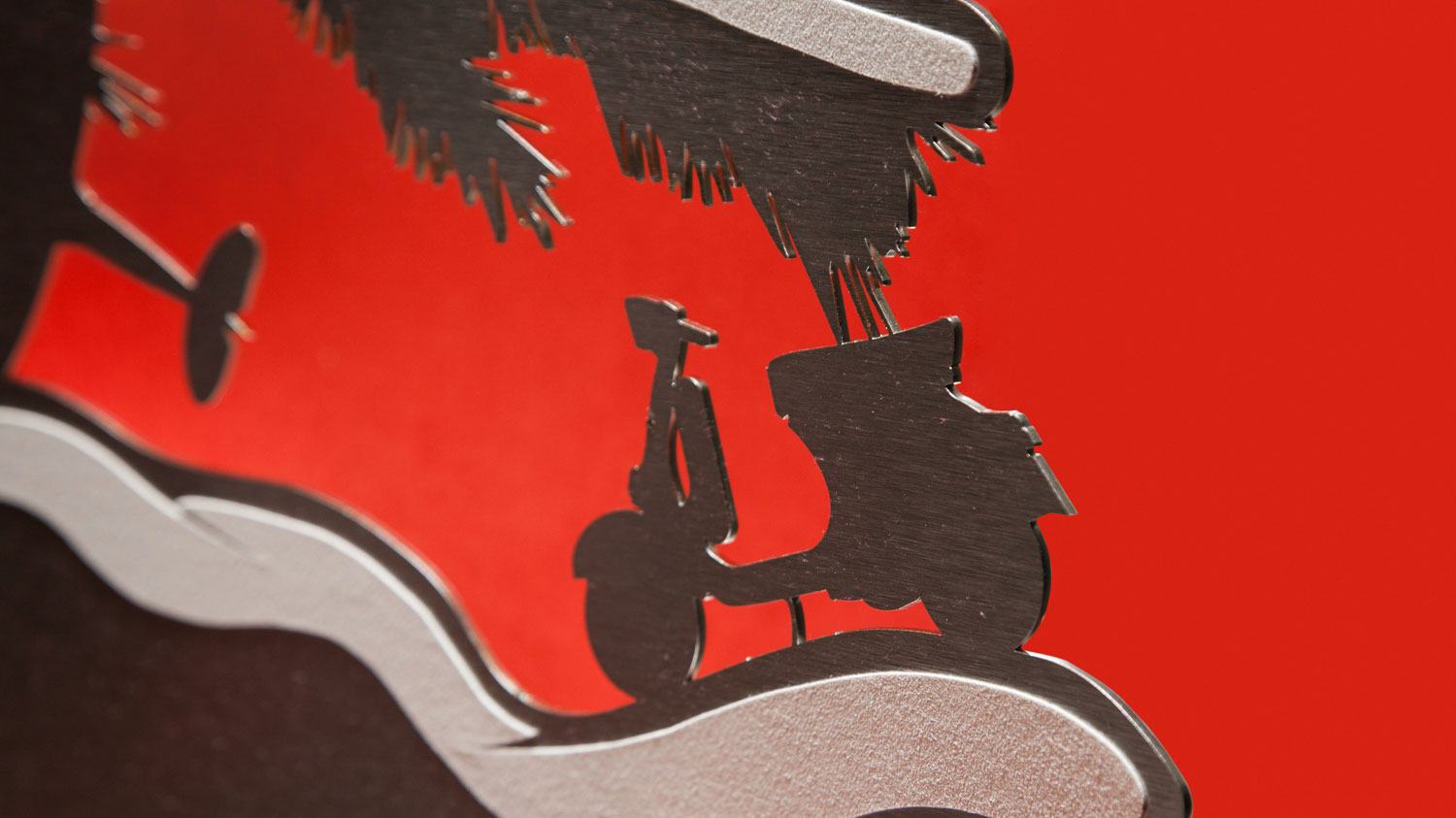 Scherenschnitt-Motiv einer Vespa auf rotem Hintergrund, Teil der IWC-Weihnachtskampagne von MORE PIOUS STUDIOS.