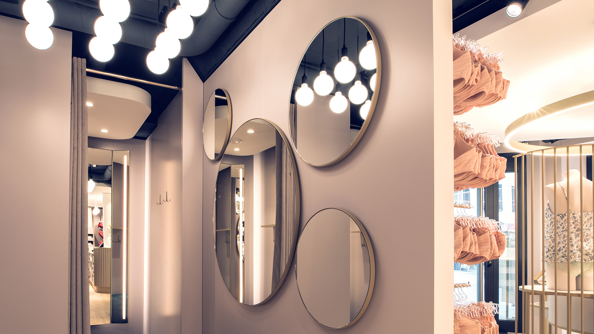 Runde Spiegelwand mit stilvoller Beleuchtung in einem Beldona-Geschäft, gestaltet von MORE PIOUS STUDIOS für eine visuelle Kampagne.