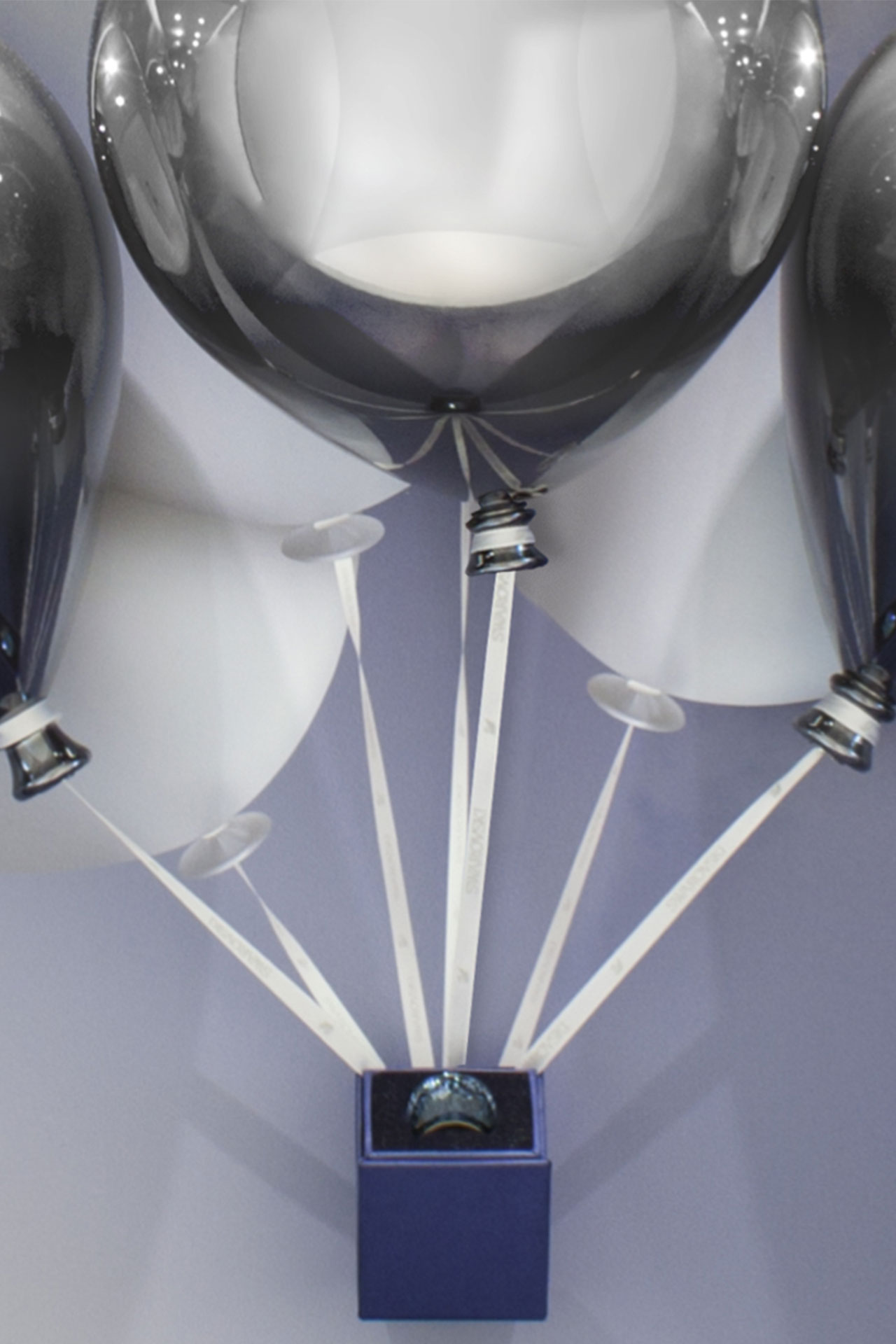 Detailaufnahme der silbernen Luftballons im Swarovski-Schaufensterdisplay mit Produktpräsentation.